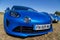 blue new Renault Alpine A110 car exhibited at the tour de france in small village contryside