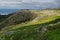 Blue north sea and bright green valley of tundra - view from granite highlands in sunny day, arctic, Norway.