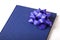 Blue notebook, calendar, book with a big blue round ribbon / bow decoration attached closeup, gift, knowledge