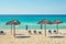 Blue ocean and white sandy beach with umbrellas on Caribbean island