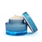 Blue open jar with a lid with beige cosmetic cream. Front view. Women`s cosmetics.