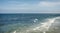 Blue open ocean photo of the North Sea near the shoreline, with boats on the horizon