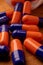 blue and orange pills on a wooden table, showcasing the natural and organic treatment options available, inspired by