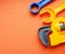 Blue and orange toy tools on a dark orange background. wrenches and other toy tools