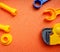 Blue and orange toy tools on a dark orange background. wrenches and other toy tools