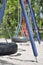 Blue and orange tyre swing set on a children\\\'s playground on sunny summer day. Tire swing with black tires, metallic chains