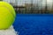 blue paddle tennis court, one ball on the line, one ball on the line