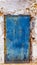Blue painted metal door with drilled flower pattern. Rusty, stained and with fingerprints. Orange, blue, yellow. Scratched and de