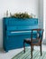 Blue painted old piano decorated with long Christmas garland