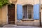 Blue painted shutters on an iron barred window