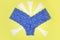 Blue panties and sanitary white napkins for woman, menstrual pads on a yellow background. Menstruation cycle. Hygiene and