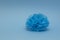 Blue paper pompom for a decoration on blue background. Home, wedding, party decoration. Background in minimal style.