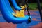 Blue park swing in raindrops.Yellow autumn oak leaves