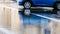 Blue parked car outdoors with reflect in wet asphalt