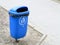 Blue pastic garbage bin or can on street
