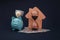 Blue piggy bank with model of house, hourglass and money banknotes on blue background. Savings money for buy house