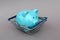 Blue piggy bank piglet lies in a miniature basket for the buyer