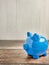 The blue piggy bank on wood table for earn or saving concept