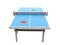 Blue ping-pong table with red and green paddles and ball