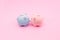 A blue and a pink piggy bank on pastel pink background. Valentines day creative concept. Love and money contemporary artistic