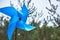 Blue pinwheel in front of a field of pinetree at an elementary school in South Korea