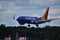 Blue plane with yellow and red empennage landing at T.F. Green Airport