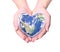 Blue planet in heart shape over woman human hands isolated