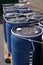 Blue plastic 55 gallon drums full of various flammable waste at a recycling plant