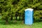 Blue plastic dry closet in the city park. Biotoilet in the recreation area. Mobile public portable toilet for walking people in