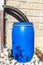 Blue plastic rain water barrel. watering the garden. Water saving. Water supply for dry summer. Rainwater drainage