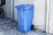 Blue plastic trash can in Europe. Household trash, storage on the street near the wall in one blue tank