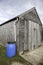 Blue plastic water attached to wooden shed