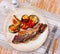on blue plate-grilled beef ribs with fried vegetables-aubergine, pepper,onion