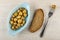 Blue plate with marinated champignons, slice of bread, mushroom on fork.on table. Top view