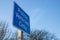 Blue Police vehicles onlye road traffic sign with tress and blue sky in the background.  Close up shot