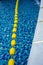 Blue pool water and yellow swimming lane marker in swimming pool