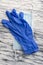 Blue protective medical gloves and medical surgical disposable mask on wooden gray background