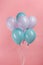 Blue and purple festive balloons on pink background.