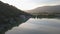 Blue quiet lake with green surrounding mountains.