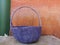 Blue rattan basket on gray concrete table, orange and green  color painting on surface mortar wall texture cement plaster masory