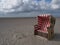 Blue and red beach chairs on the Island Langeoog with a beautiful cloudscape in the background