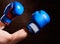 Blue and red boxing gloves on hands on brown background.