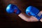 Blue and red boxing gloves on hands on brown background.