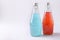 Blue and red drinks with basil seeds or falooda seeds or tukmaria in bottles on white background, Copy space