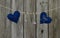 Blue and red fabric hearts and locks hanging on clothesline by rustic wooden background