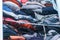 Blue and red hues of clothing in a woman`s closet, folded but messy, in need of closet organization. Depicting donating clothes, t