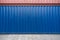 Blue and Red steel cargo containers stacked on concrete floor. Industrial background