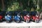 Blue and red tricycles on the background of roadside vegetation