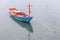 Blue and red vacant fishermanâ€™s rowboat floating on sea, traditional fishing in Thailand.