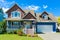 Blue residential house with concrete driveway in front and blue sky background.